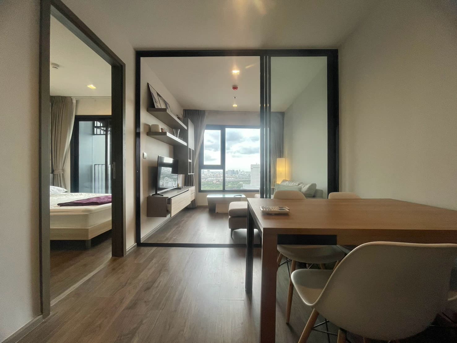 Glass-partition bedroom, warm wood — Life Ladprao Valley
